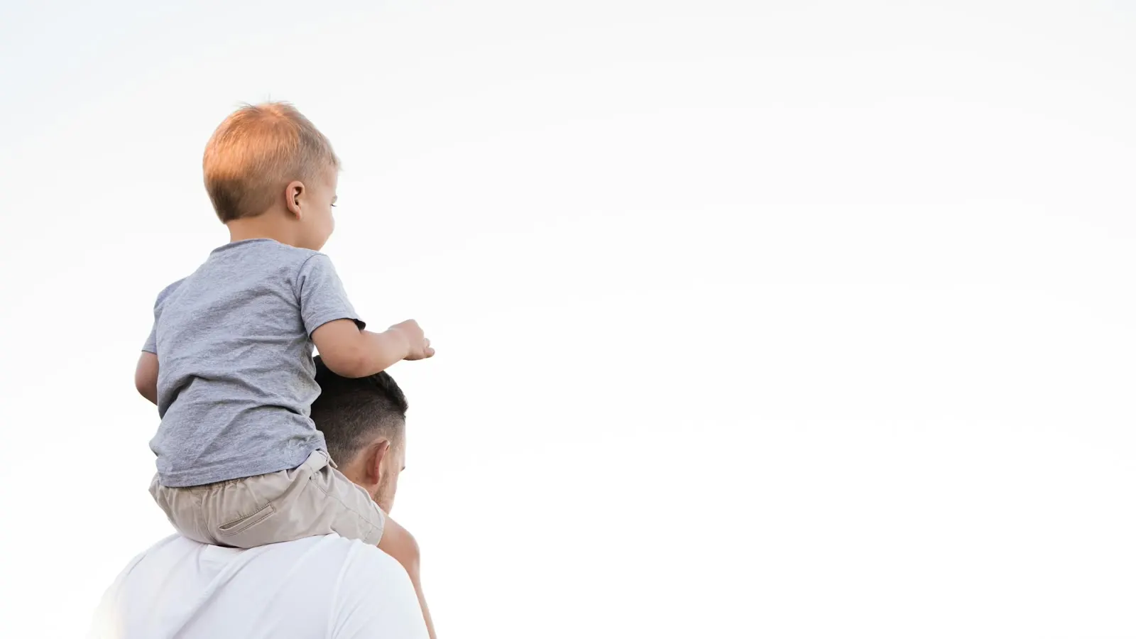 A child riding safely on an adult’s shoulders