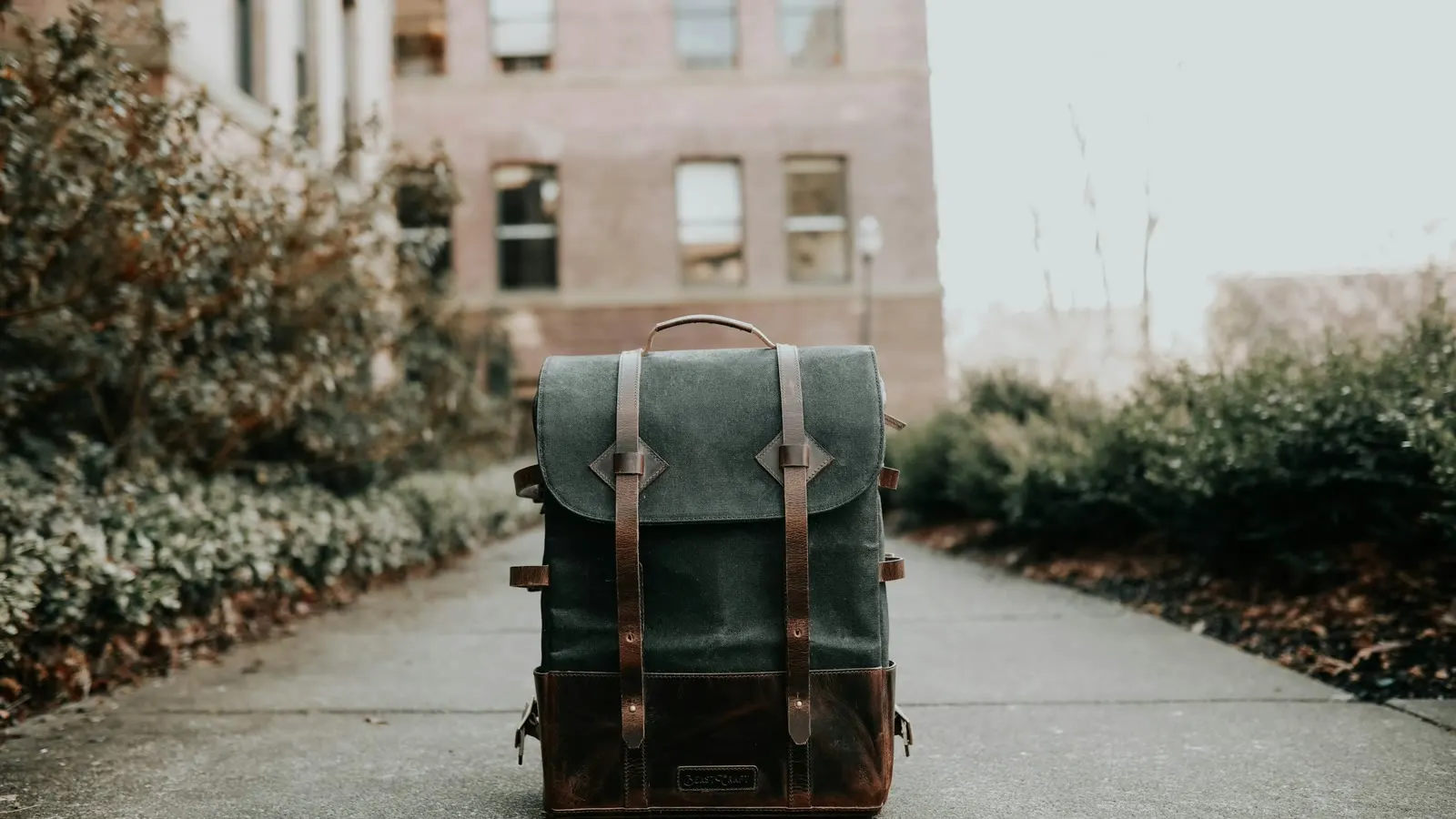 A school backpack standing on a quiet path