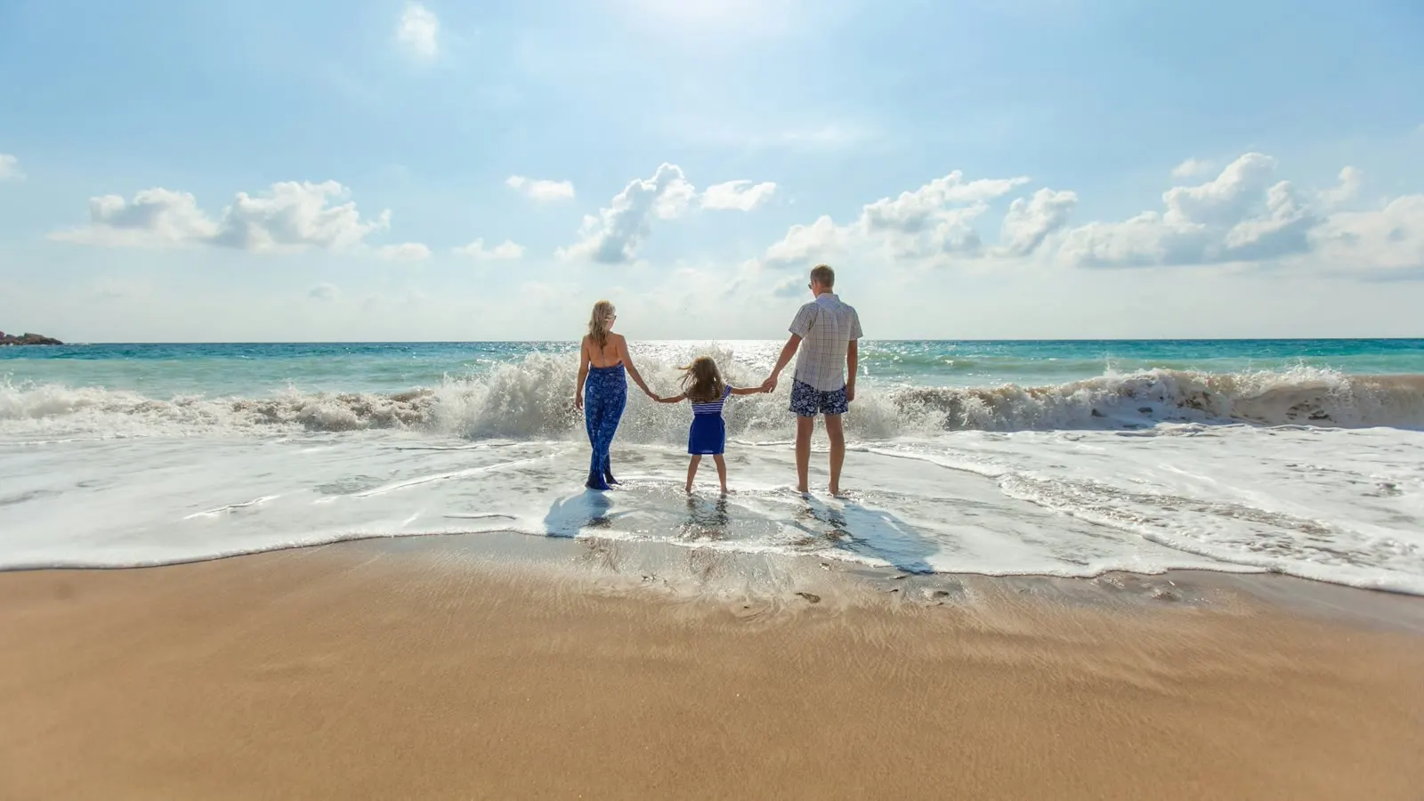 A family standing together at the edge of the sea