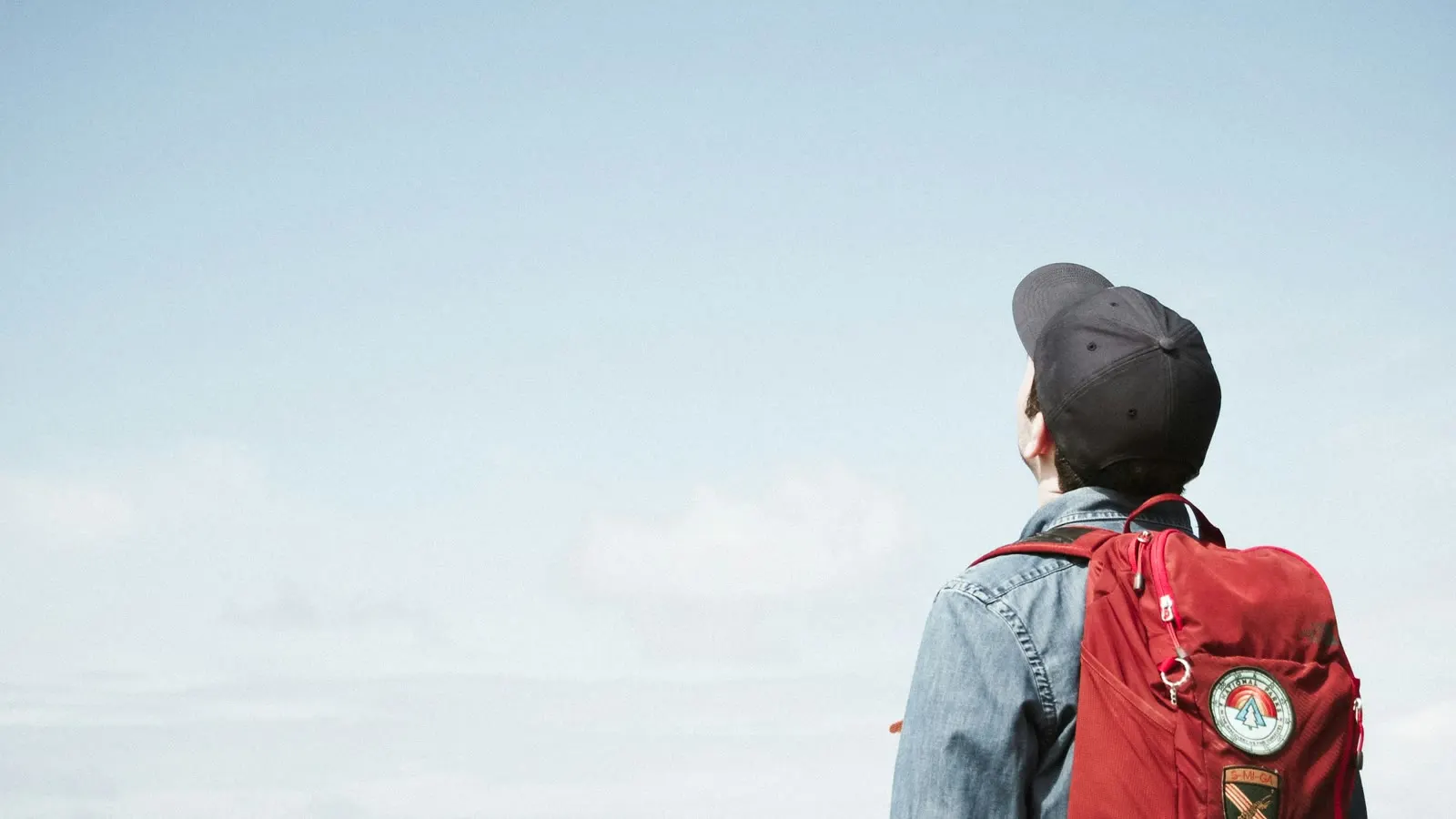 A child wearing a red backpack outdoors